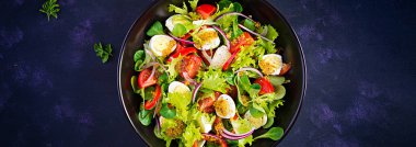 Sebzeli taze salata, domates, kırmızı soğan, marul ve bıldırcın yumurtası. Sağlıklı gıda ve diyet konsepti. Vejetaryen yemeği. Üst görünüm, afiş