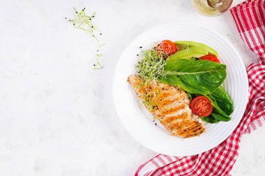 Salata, taze domates ve avokado ile ızgara tavuk filetosu. Sağlıklı yiyecekler, ketojenik diyet, diyet öğle yemeği konsepti. Keto / Paleo diyet menüsü. Üst manzara, düz uzanma