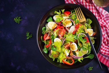 Sebzeli taze salata, domates, kırmızı soğan, marul ve bıldırcın yumurtası. Sağlıklı gıda ve diyet konsepti. Vejetaryen yemeği. Üst görünüm, genel görünüm