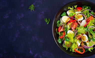 Sebzeli taze salata, domates, kırmızı soğan, marul ve bıldırcın yumurtası. Sağlıklı gıda ve diyet konsepti. Vejetaryen yemeği. Üst görünüm, genel görünüm