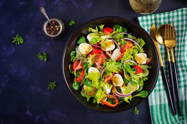 Sebzeli taze salata, domates, kırmızı soğan, marul ve bıldırcın yumurtası. Sağlıklı gıda ve diyet konsepti. Vejetaryen yemeği. Üst görünüm, genel görünüm