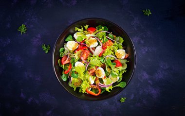 Sebzeli taze salata, domates, kırmızı soğan, marul ve bıldırcın yumurtası. Sağlıklı gıda ve diyet konsepti. Vejetaryen yemeği. Üst görünüm, genel görünüm