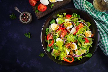 Sebzeli taze salata, domates, kırmızı soğan, marul ve bıldırcın yumurtası. Sağlıklı gıda ve diyet konsepti. Vejetaryen yemeği. Üst görünüm, genel görünüm