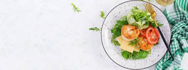 Ketogenik öğle yemeği. Domatesli tavuk burger, salatalık, peynir ve ekmeksiz roka salatası. Tavuk köftesi. Sağlıklı yiyecekler. Keto / paleo diyeti. Üst görünüm, genel görünüm, afiş