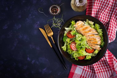 Salata, taze domates ve avokado ile ızgara tavuk filetosu. Sağlıklı yiyecekler, ketojenik diyet, diyet öğle yemeği konsepti. Keto / Paleo diyet menüsü. Üst manzara, düz uzanma