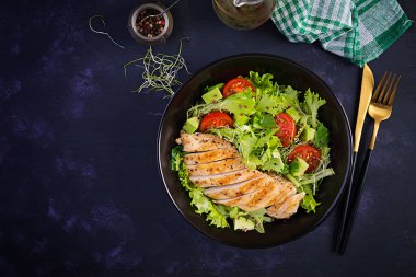 Salata, taze domates ve avokado ile ızgara tavuk filetosu. Sağlıklı yiyecekler, ketojenik diyet, diyet öğle yemeği konsepti. Keto / Paleo diyet menüsü. Üst manzara, düz uzanma