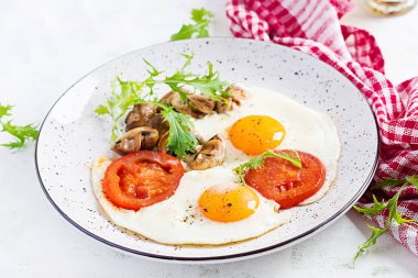 Ketojenik gıda. Yağda yumurta, mantar ve dilimlenmiş domates. Keto, paleo kahvaltı..