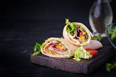 Jambonlu taze tortilla sargıları ve tahta tahtada taze sebzeler. Biftek dürümü. Meksika mutfağı. Boşluğu kopyala