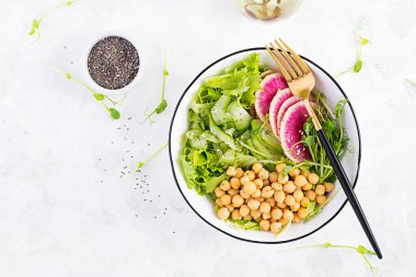 Moda salatası. Nohut, karpuz turpu, salatalık ve bezelye filizli vejetaryen Buda kasesi. Sağlıklı dengeli beslenme. Üst görünüm, genel görünüm, düz görünüm