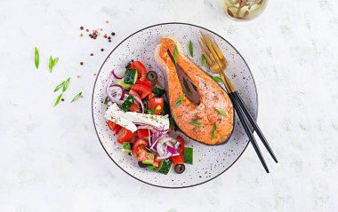 Ketogenik öğle yemeği. Yunan salatasıyla süslenmiş fırında somon balığı. Sağlıklı bir akşam yemeği. Keto / paleo diyeti. Üst görünüm, düz görünüm, kopyalama alanı