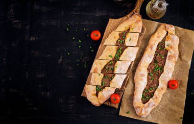 Kıymalı Türk pidesi, Kiymali Pide. Geleneksel Türk mutfağı. Etli Türk pizzası. Üst görünüm, genel görünüm