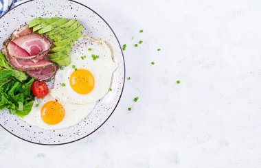Ketogenik / paleo diyeti. Yağda yumurta, jambon, avokado ve taze salata. Keto kahvaltısı. Brunch olsun. Üst görünüm, genel görünüm