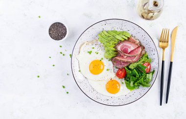 Ketogenik / paleo diyeti. Yağda yumurta, jambon, avokado ve taze salata. Keto kahvaltısı. Brunch olsun. Üst görünüm, genel görünüm