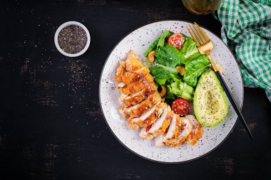 Moda salatası. Salata, taze domates ve avokado ile ızgara tavuk filetosu. Sağlıklı yiyecekler, ketojenik diyet, diyet öğle yemeği konsepti. Keto / Paleo diyet menüsü. Üst görünüm, genel görünüm, düz görünüm