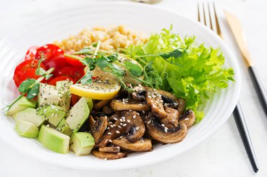 Moda salatası. Mercimek, avokado, mantar, marul, domates ve chia tohumlu vejetaryen Buda kasesi. Etsiz Uluslararası Gün. Vejetaryen salatası.