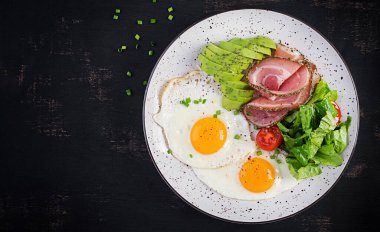 Ketogenik / paleo diyeti. Yağda yumurta, jambon, avokado ve taze salata. Keto kahvaltısı. Brunch olsun. Üst görünüm, genel görünüm