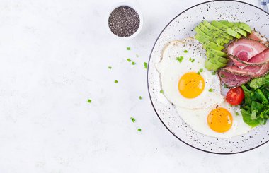 Ketogenik / paleo diyeti. Yağda yumurta, jambon, avokado ve taze salata. Keto kahvaltısı. Brunch olsun. Üst görünüm, genel görünüm