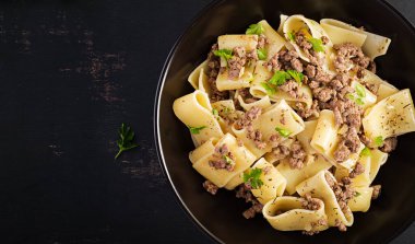 Siyah kasede kıymalı Calamarata makarnası. İtalyan mutfağı. Üst görünüm, genel görünüm
