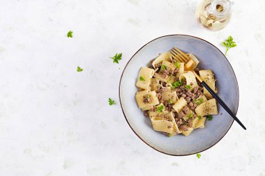 Mavi kasede kıymalı Calamarata makarnası. İtalyan mutfağı. Üst görünüm, genel görünüm