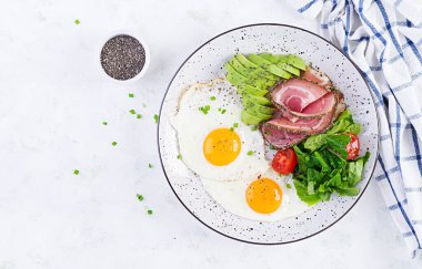 Ketogenik / paleo diyeti. Yağda yumurta, jambon, avokado ve taze salata. Keto kahvaltısı. Brunch olsun. Üst görünüm, genel görünüm