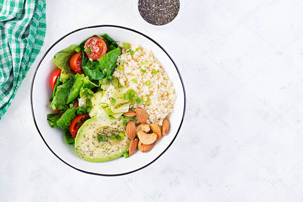 Trendy salad. Vegan Buddha bowl with bulgur, avocado, cucumber, lettuce, tomatoes and chia seeds. International Day Without Meat. Vegetarian salad. Top view, overhead, flat lay