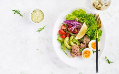 Sağlıklı yiyecekler. Yumurtalı ton balığı salatası, marul, vişneli domates, avokado ve kırmızı soğan. Fransız mutfağı. Üst görünüm, kopyalama alanı, düz uzanma