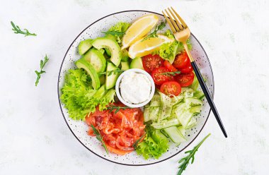 Tuzlu balık salatası, avokado, kiraz domatesleri, salatalık, marul ve krem peynir. Balık menüsü. Beslenme menüsü. Deniz mahsulleri, somon. Üst görünüm, genel görünüm, düz görünüm
