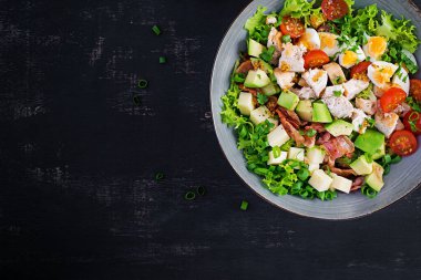 Tavuk, avokado, pastırma, domates, peynir ve yumurtalı sağlıklı Cobb salatası. Amerikan yemeği. Üst Manzara. Düz uzanın, başınızın üstünde