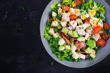 Tavuk, avokado, pastırma, domates, peynir ve yumurtalı sağlıklı Cobb salatası. Amerikan yemeği. Üst Manzara. Düz uzanın, başınızın üstünde