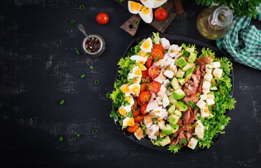 Tavuk, avokado, pastırma, domates, peynir ve yumurtalı sağlıklı Cobb salatası. Amerikan yemeği. Üst Manzara. Düz uzanın, başınızın üstünde