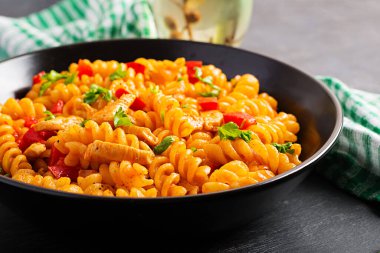 Tavuklu Fusilli makarna ve domates soslu tatlı biber. İtalyan Mutfağı.