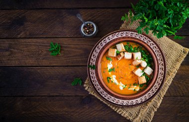 Kızarmış ekmek ve maydanozla servis edilen bir kasede balkabağı çorbası. Vejetaryen diyet çorbası. Vejetaryen yemeği. Üst görünüm, genel görünüm