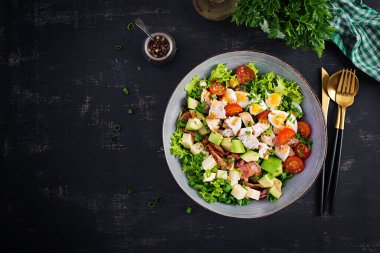 Tavuk, avokado, pastırma, domates, peynir ve yumurtalı sağlıklı Cobb salatası. Amerikan yemeği. Üst Manzara. Düz uzanın, başınızın üstünde