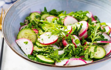 Vejetaryen sebze salatası turp, salatalık, roka ve yeşil soğan. Sağlıklı vejetaryen yemekleri.