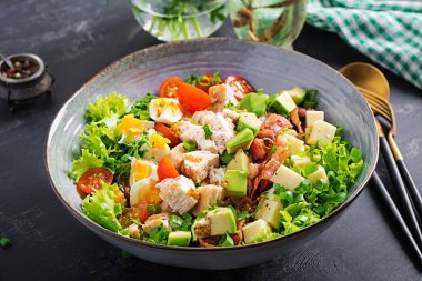 Healthy cobb salad with chicken, avocado, bacon, tomato, cheese and eggs. American food. clipart