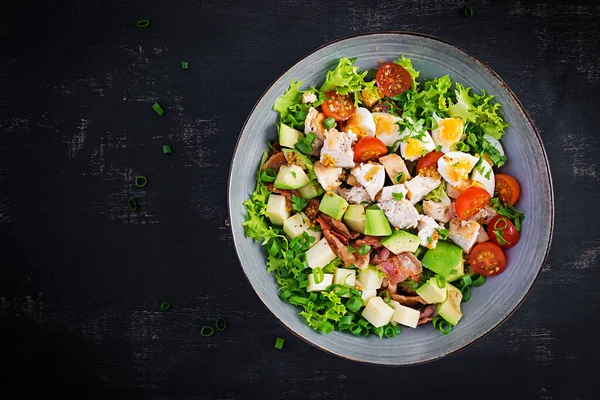 Tavuk, avokado, pastırma, domates, peynir ve yumurtalı sağlıklı Cobb salatası. Amerikan yemeği. Üst Manzara. Düz uzanın, başınızın üstünde