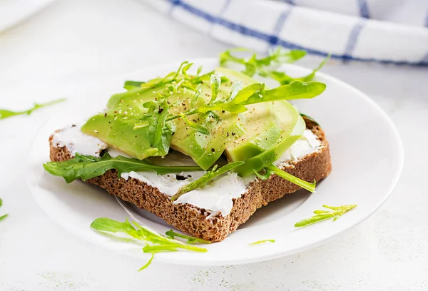 Sandwich Pane Crema Formaggio Fette Avocado Piatto Uno Sfondo Leggero — Foto Stock