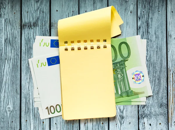 Εκατό ευρώ τραπεζογραμμάτια και κίτρινο σημειωματάριο (Notepad) — Φωτογραφία Αρχείου