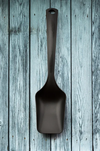 Black spoon on wooden panel — Stock Photo, Image