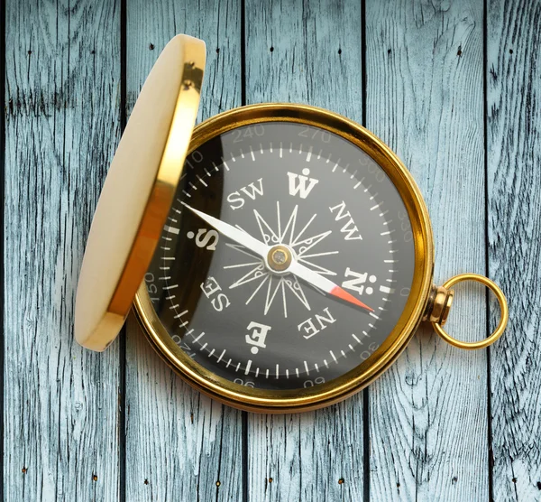 Golden vintage compass on wooden table — Stock Photo, Image