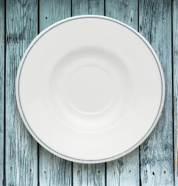 White plate on wooden table — Stock Photo, Image