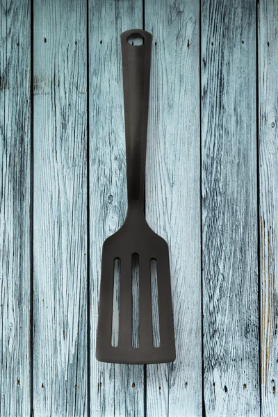Black spatula on wooden panel — Stock Photo, Image