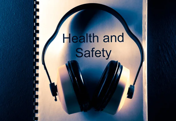 Health and safety document with earphones — Stock Photo, Image