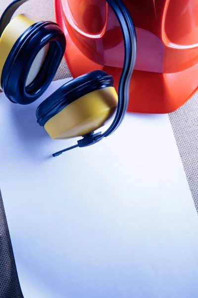 Шлем, наушники и лист бумаги — стоковое фото