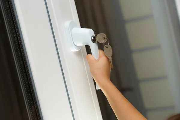 Child hand on secure window handle — Stock Photo, Image