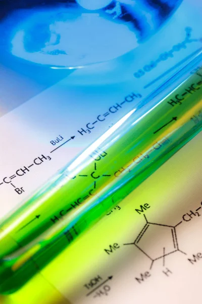 Chemical tube with reaction formula — Stock Photo, Image