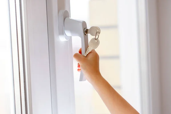 Child hand on secure window handle — Stock Photo, Image