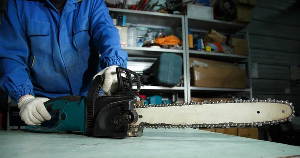 Motor chainsaw in man's hands