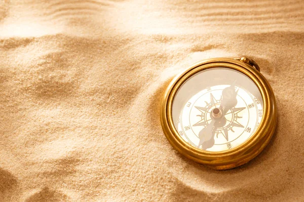 Goldener Kompass mit Sand am Strand — Stockfoto
