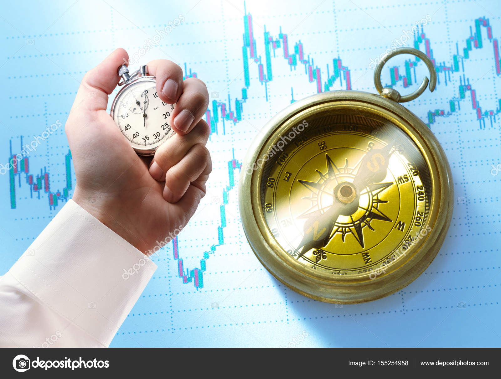 Candlestick chart, compass and stopwatch in male hand Stock Photo by